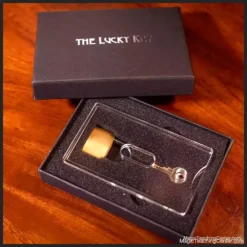 Pegani - The Lucky Key magic trick tutorial cover, depicting a padlock, a set of eight keys, and a banknote within a transparent container, symbolizing the classic mentalism prediction effect.