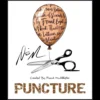 Close-up view of a hand holding a balloon that appears to be signed and restored, illustrating the 'Puncture' magic trick by Francis Mcallister.