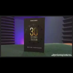 Richard Sanders performing the '30 Seconds to Stun' magic trick, showing a playing card impossibly dangling from his mouth with a Bicycle deck in hand. Instant download for self-working card magic.