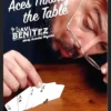 Javi Benitez demonstrating the Aces Through the Table card trick, showing four playing card aces appearing to penetrate a solid table surface during a magic tutorial.