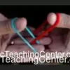 Cyril Thomas demonstrating the Link King rubber band magic trick in a digital video tutorial, showcasing two linked rubber bands.