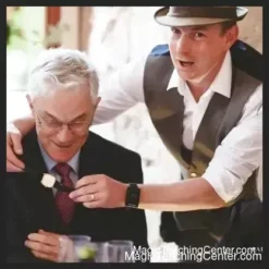 James Brown performing the 'Paperballs' close-up magic trick, holding a crumpled paper ball with a focused expression, teaching sleight of hand and misdirection