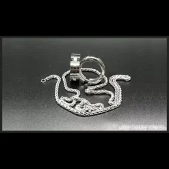 Close-up image of a solid metal ring held next to a glass bottle, illustrating the impossible penetration magic trick taught by Viktor Voitko's Instant Ring video tutorial.