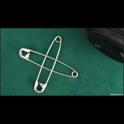 Magia Estudio Safety Pin Magic Tutorial: Close-up of hands performing a magic trick with linked safety pins.