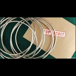 A close-up image of a magician's hands demonstrating the linking Chinese Rings, illustrating the Magia Estudio digital magic tutorial.