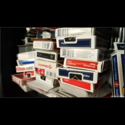 A close-up of a magician's hand fanning a deck of playing cards, illustrating the precise techniques of ordered and memorized decks taught in the Magia Estudio video course.