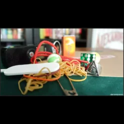 Close-up of a magician's hands performing an intricate rubber band magic trick, demonstrating linking bands or a vanish, representing the Magia Estudio - Gomas Elásticas video course.