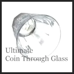 Close-up image of a hand holding a glass with a coin visibly embedded into its side, showcasing the Ultimate Coin Thru Glass magic trick effect from SEO Magic.