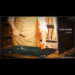 Takahiro performing the Silver Diamond advanced Cylinder & Coin magic trick with coins and a cylinder.