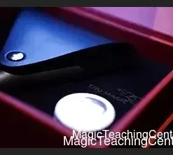 Vega magic trick setup featuring a hand holding coins and a transforming cylinder, by Tjiu Agus Haryanto and Handy Altan.