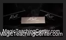 A close-up of a magician's hands demonstrating a card vanishing trick using the D'Albéniz ROLL invisible system.