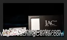 D'Albéniz AC Just A Card magic gimmick displayed with playing cards, showcasing its compact design for advanced card manipulation.