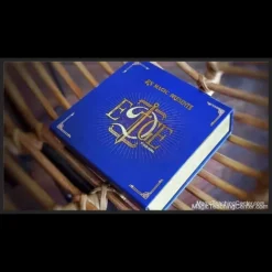 Rizki Nanda performs 'Edge,' a visual magic trick where a signed playing card impossibly penetrates a red Bicycle card box. The image captures the card seemingly melting through the solid cardboard.